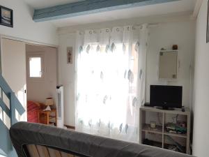 salon z oknem i kanapą w obiekcie Petit pavillon St Pierre w mieście Saint Pierre La Mer