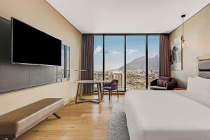 a hotel room with a bed and a flat screen tv at Fiesta Americana Monterrey Pabellón M. in Monterrey