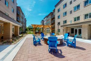 a patio with blue chairs and a table in a building at WaterWalk Raleigh RTP in Durham