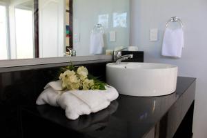 a bathroom with a sink and towels on a counter at Amoa Resort Savaii in Tuasivi