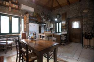 cocina con mesa de madera y nevera en Stone house with panoramic view, en Tyros