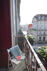 uma toalha sentada numa cadeira na varanda em Santo da Casa / Sc apartments em Porto