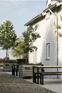 dwie ławki przed białym budynkiem w obiekcie Brut the lodges w mieście Reijmerstok