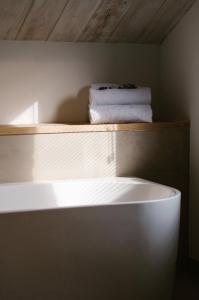 a white shelf with two towels on top of it at Brut the lodges in Reijmerstok