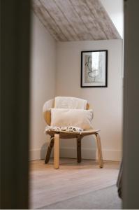 a chair with a pillow sitting in a room at Brut the lodges in Reijmerstok