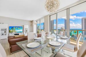 a dining room with a glass table and chairs at Beachwalk Resort #2301 - MODERN RESORT 3BDR and 3BA - BALCONY, GYM, AMAZING POOL in Hallandale Beach