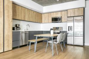 a kitchen with wooden cabinets and a table and chairs at Downtown 1BR w Pool Gym WD nr Staples Center LAX-551 in Los Angeles