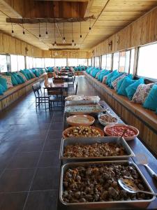 ein Buffet in einem Raum mit vielen Tabletts Essen in der Unterkunft Matan Rural Lodge in Tufailah