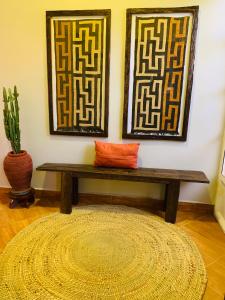 a bench in a room with a rug and two pictures at Arches&Palms Residence in Arusha