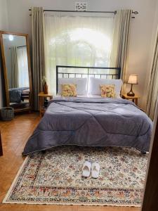 a bedroom with a bed and two shoes on a rug at Arches&Palms Residence in Arusha