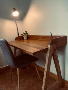 a wooden desk with a chair and a lamp at Arches&Palms Residence in Arusha