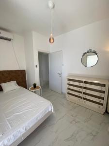 a white bedroom with a bed and a mirror at APARTMENT OSCAR BEACH 2 in Bat Yam