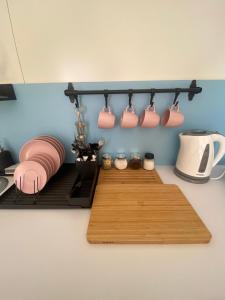 a kitchen with pink mugs hanging on a wall at APARTMENT OSCAR BEACH 2 in Bat Yam