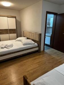um quarto com 2 camas e piso em madeira em Rooms Ideal em Struga