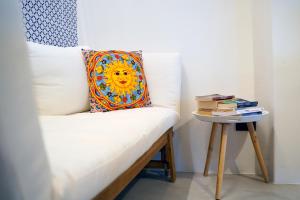 un banc avec un oreiller et une table de chevet avec des livres dans l'établissement Villa Grazia Lipari, à Lipari
