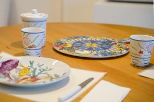 a wooden table with two plates and two cups at Villa Grazia Lipari in Lipari