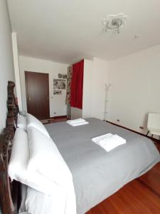 una camera da letto con un grande letto con lenzuola bianche di Casa Doretta - Camere Rooms a Verona