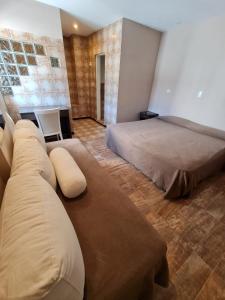 sala de estar con 2 camas y sofá en Hotel Siglo Sexto en Termas de Río Hondo