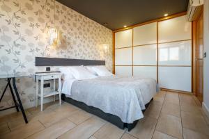 a bedroom with a bed and a side table at Apartahotel Comforsuite in Boecillo