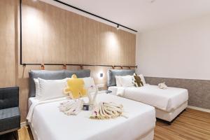 a hotel room with two beds with stuffed animals on them at Bagan Suite in Butterworth