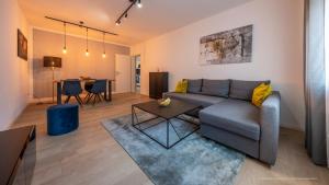 FLAIR: stylisches Apartment - Netflix - BASF - Uni Mannheim في لودفيغسهافن أم راين: غرفة معيشة مع أريكة وطاولة