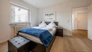 a bedroom with a bed with blue sheets and a window at FLAIR: stylisches Apartment - Netflix - BASF - Uni Mannheim in Ludwigshafen am Rhein