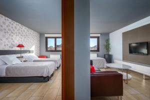 a hotel room with two beds and a flat screen tv at Apartahotel Comforsuite in Boecillo