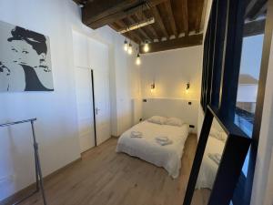 een kleine slaapkamer met een bed in een kamer bij ARQUEBUSE proche gare in Dijon