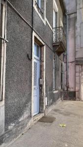 - un bâtiment avec une porte blanche et un balcon dans l'établissement ARQUEBUSE proche gare, à Dijon