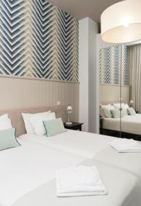 ein Schlafzimmer mit einem großen weißen Bett und einem Spiegel in der Unterkunft Santo da Casa / Sc apartments in Porto