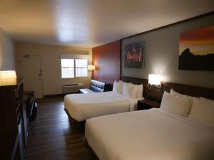 a hotel room with two beds and a couch at Days Inn by Wyndham Prescott in Prescott