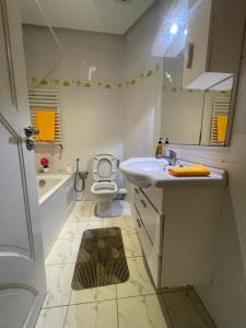 a white bathroom with a sink and a toilet at Studio richement meublé à jardin l'aouina in El Aouina