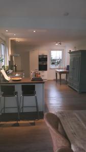 a kitchen with a counter and chairs in a room at Groot familiehuis voor 6 personen in landelijke, rustige omgeving in Breezand