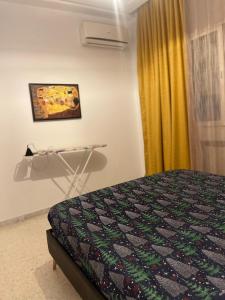 a bedroom with a bed and a curtain and a table at Studio richement meublé à jardin l'aouina in El Aouina