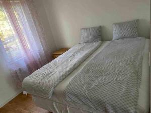 a large bed in a room with a window at Trevlig stuga med uteplats in Rimbo