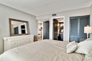 Un dormitorio blanco con una cama y un espejo. en Unit 3206 - Ocean & Racquet Resort, en St. Augustine Beach 108 fotos más