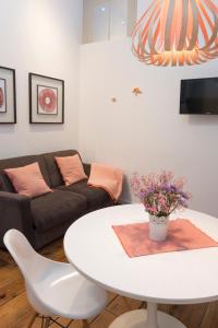 ein Wohnzimmer mit einem weißen Tisch und einer Couch in der Unterkunft Santo da Casa / Sc apartments in Porto