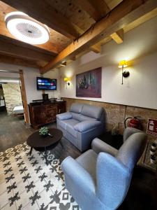 ein Wohnzimmer mit einem Sofa, Stühlen und einem TV in der Unterkunft Paella flat old town Alicante in Alicante