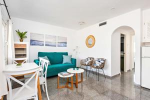 a living room with a blue couch and a table at Apartamento Menorca SON BOU 53 by Mauter Villas in Son Bou +16 photos