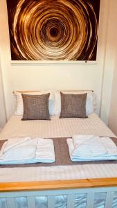 un letto con due cuscini e un dipinto sul muro di Luxury Penthouse near Swanage Beach and Town a Swanage