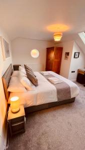 sypialnia z dużym łóżkiem z poduszkami w obiekcie Luxury Penthouse near Swanage Beach and Town w mieście Swanage
