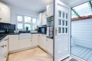 a kitchen with white cabinets and a door at Rest&Recharge at a Luxury Retreat in Manchester - Sleeps 11, 5 Bedrooms, 3 Bathrooms, Free Parking in Manchester
