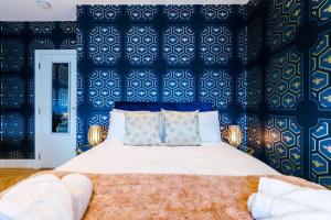 a bedroom with a bed with a blue wall at Rest&Recharge at a Luxury Retreat in Manchester - Sleeps 11, 5 Bedrooms, 3 Bathrooms, Free Parking in Manchester