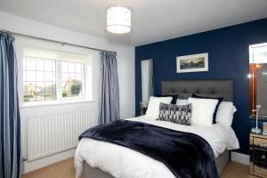 a blue bedroom with a bed and a window at Oceanside in Wyke Regis