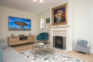 Oceanside في Wyke Regis: غرفة معيشة مع أريكة ومدفأة