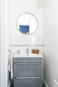 a white bathroom with a sink and a mirror at Oceanside in Wyke Regis
