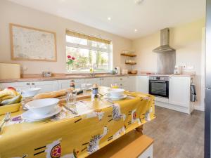 a kitchen with a wooden table with bowls on it at The Old Shepherds Cottage in Pitlessie