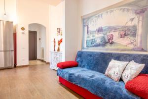 ピオンビーノにあるPiombino Apartments - Casa Romaの壁画のあるリビングルーム(青いソファ付)