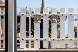 een wit hek met een paar horloges erop bij Villetta Conteamare in Marina di Modica +72 foto's