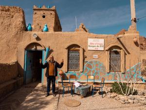 a man standing in front of a building at Chambres dans casbah - Gite D'étape Gorges De Ziz in Er Rachidia